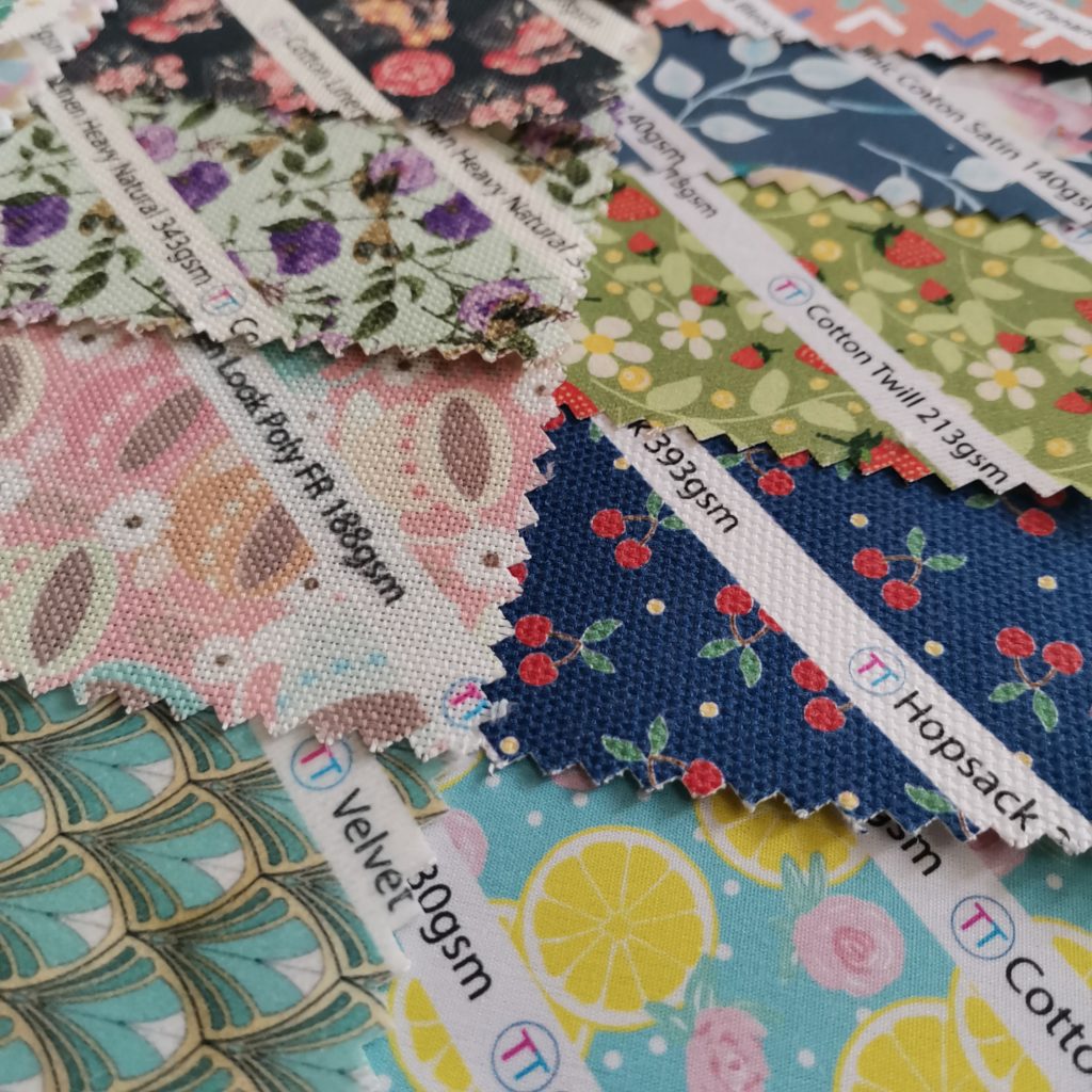 Colourful digitally printed fabric samples scattered on a table