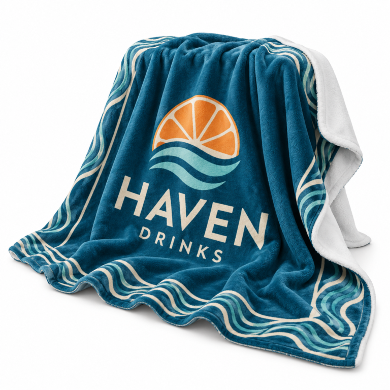 Draped teal fleece blanket with a colourful Haven Drinks logo, white reverse and soft folds on a white background